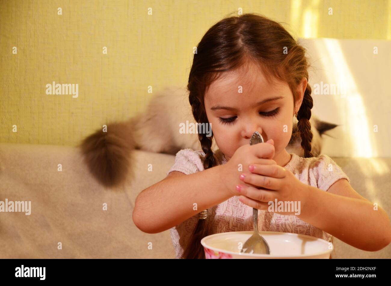 Carina bambina sta giocando e ride mentre impastando l'impasto in cucina. Foto Stock