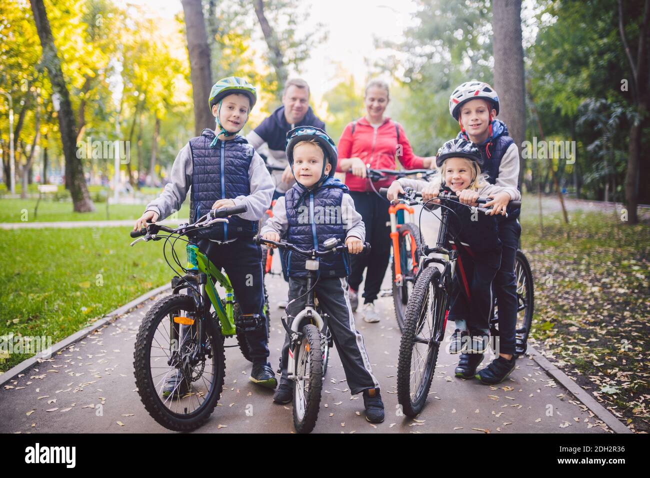 Tema famiglia sport vacanza nel parco nella natura. Grande famiglia caucasica amichevole di sei persone mountain bike equitazione nella foresta. Chil Foto Stock