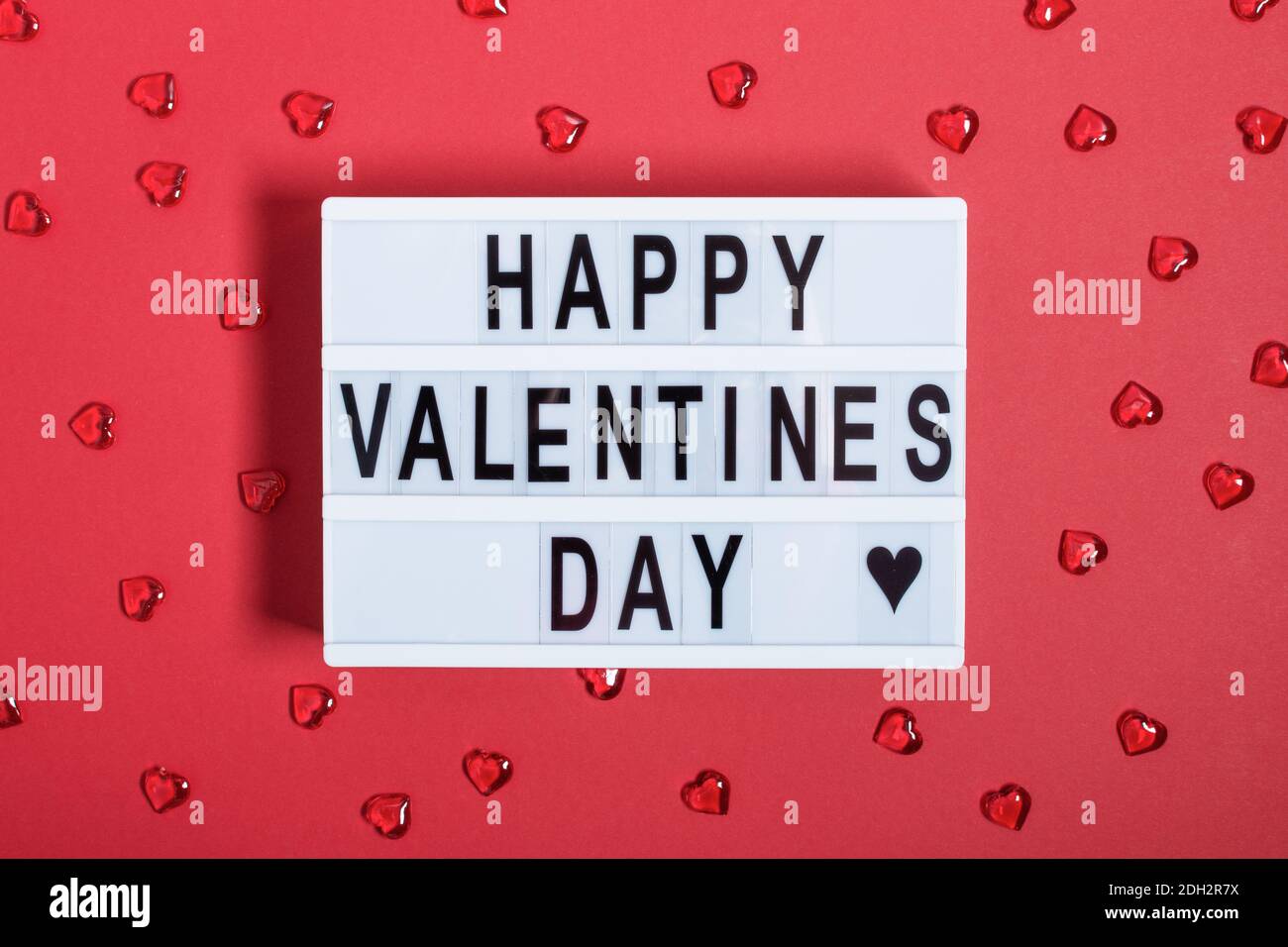 Lightbox con parole per Happy San Valentino vista dall'alto su sfondo rosso. Biglietto d'auguri per San Valentino. Foto Stock