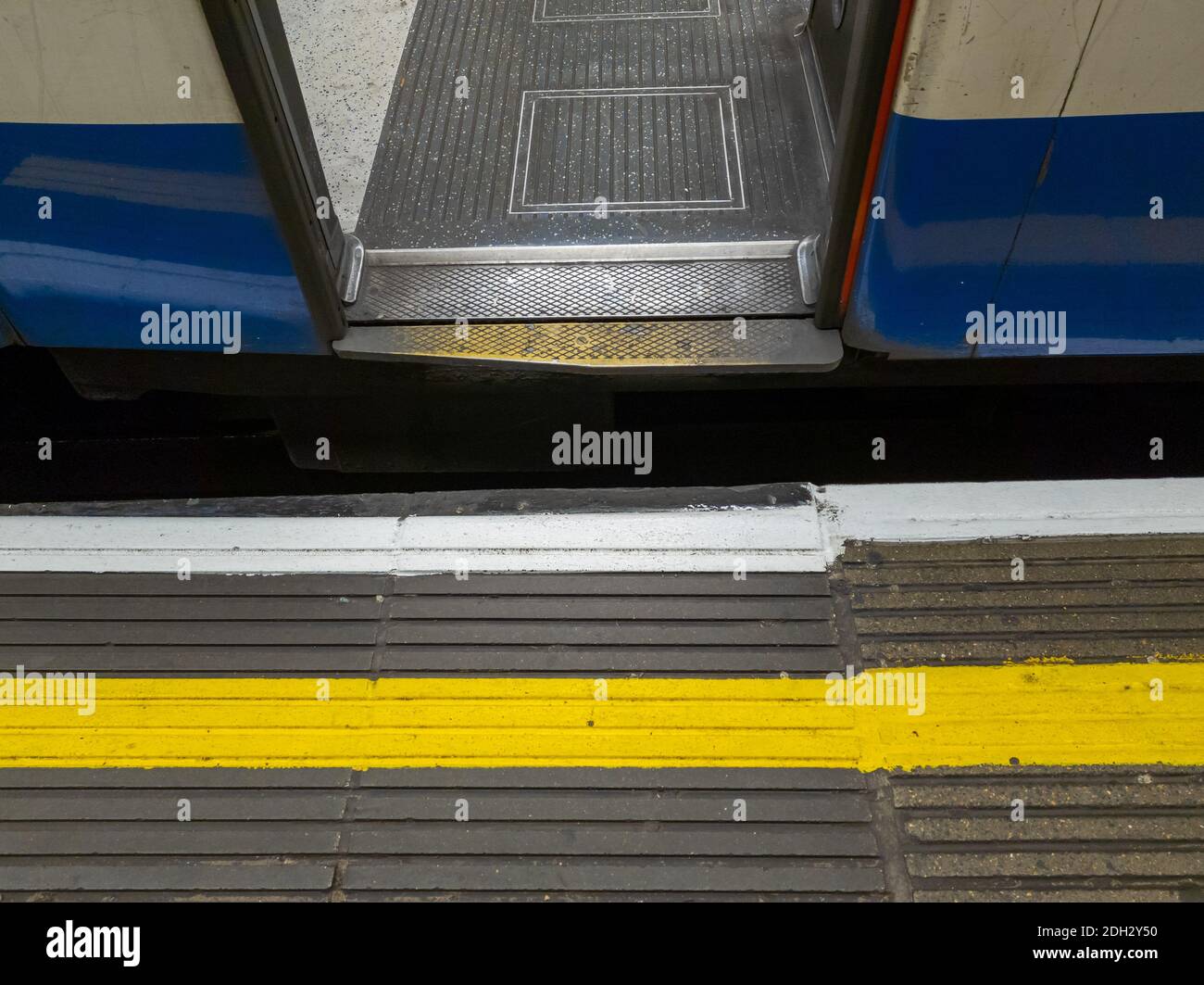 Una linea di sicurezza gialla e bianca verniciata su una piattaforma ferroviaria. Foto Stock