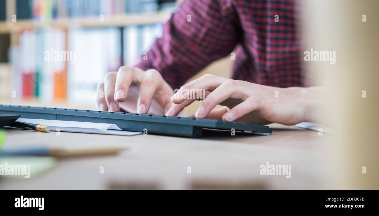 Concetto di ufficio domestico: L'uomo lavora in ufficio domestico, legando sulla tastiera Foto Stock