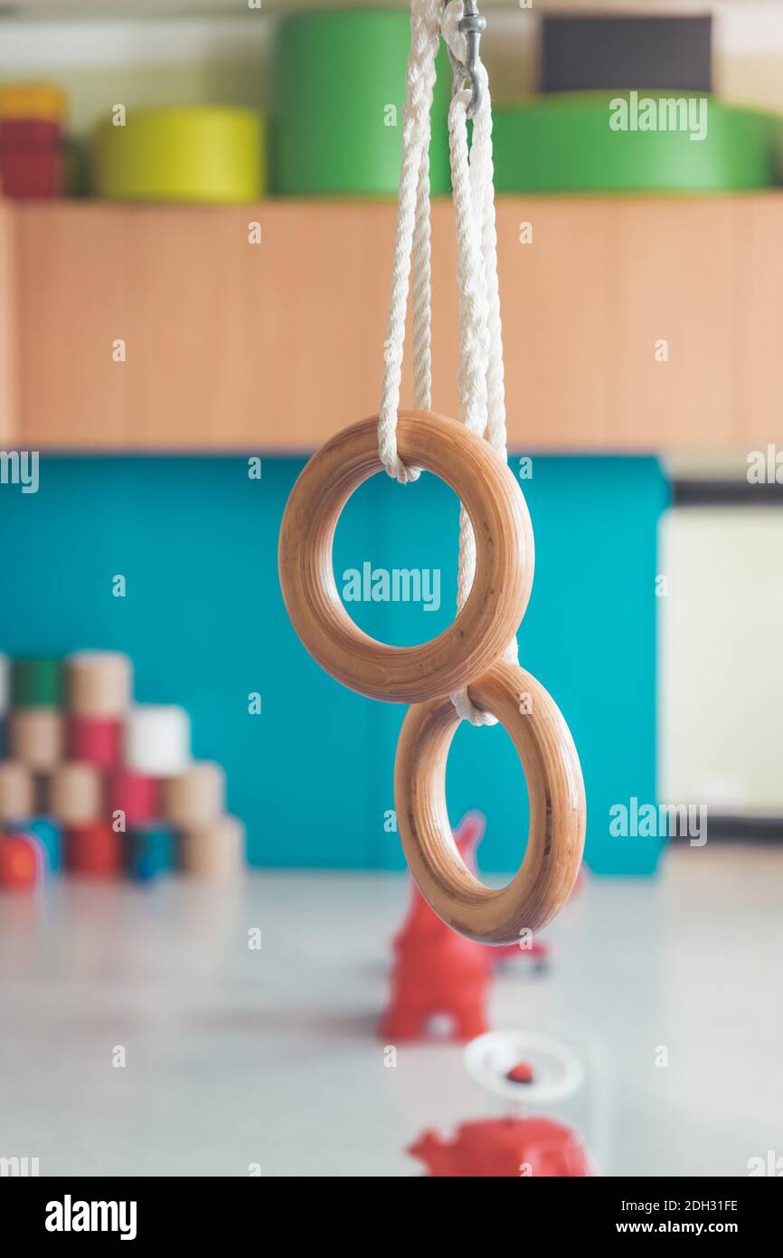 Concetto di educazione fisica: Anelli di palestra nella palestra dell'asilo Foto Stock