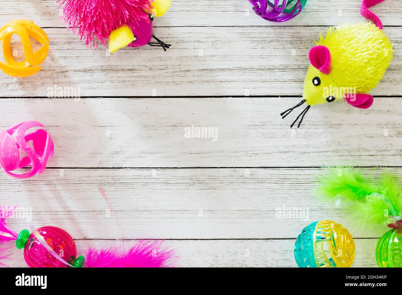 Giocattoli colorati disposti su una superficie in legno creano un'atmosfera giocosa per un'attività divertente o una festa Foto Stock