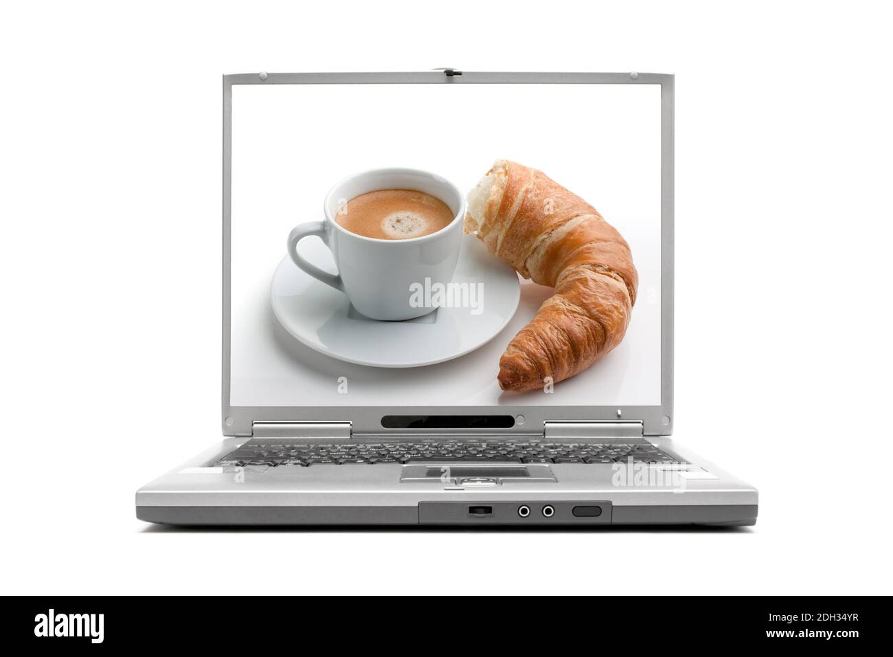 Laptop zeigt Frühstück, Croissant und Milchkaffee, Foto Stock