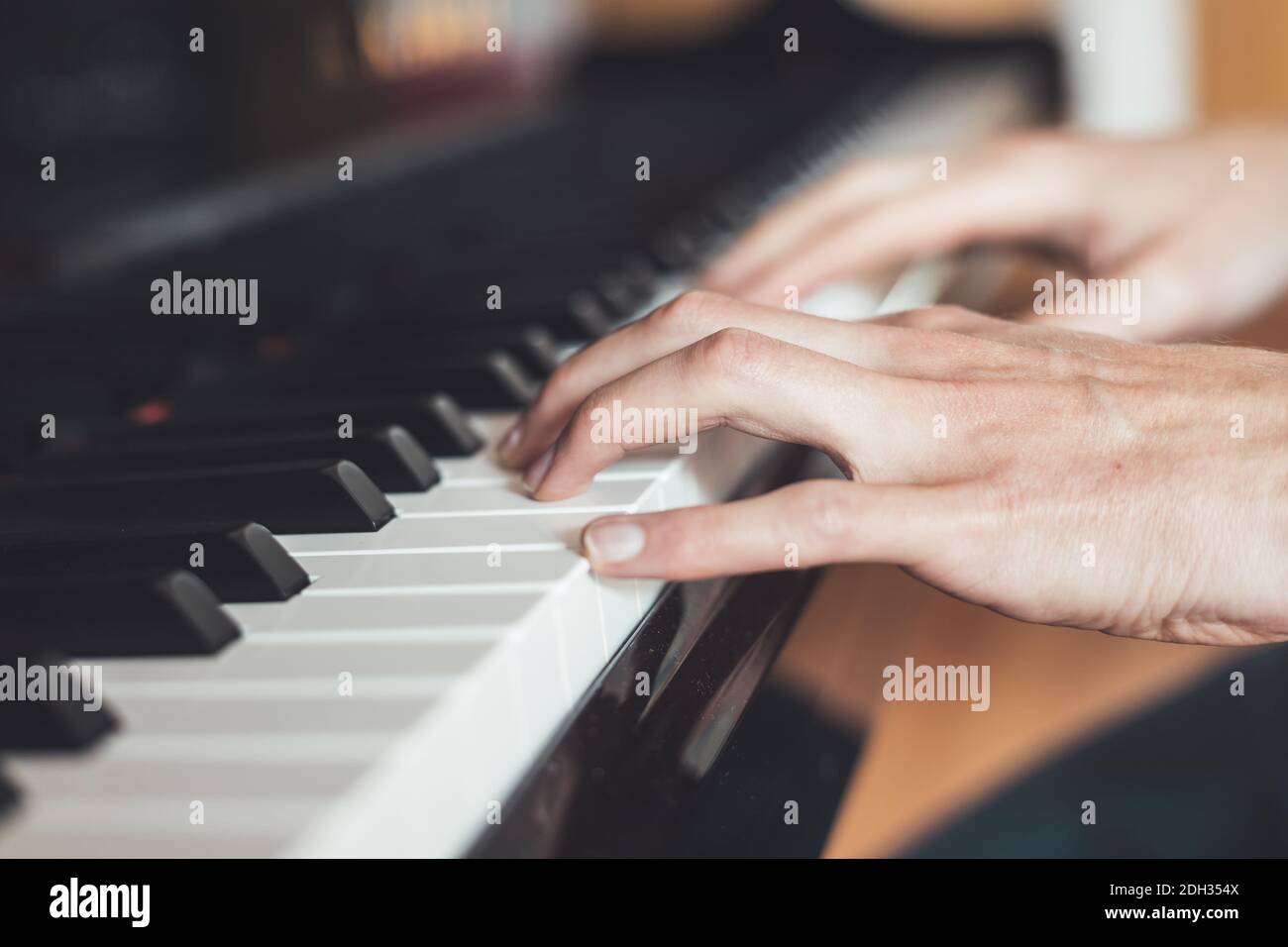 Suonare il pianoforte a casa, la vista ad angolo alto, lo sfondo sfocato. Foto Stock