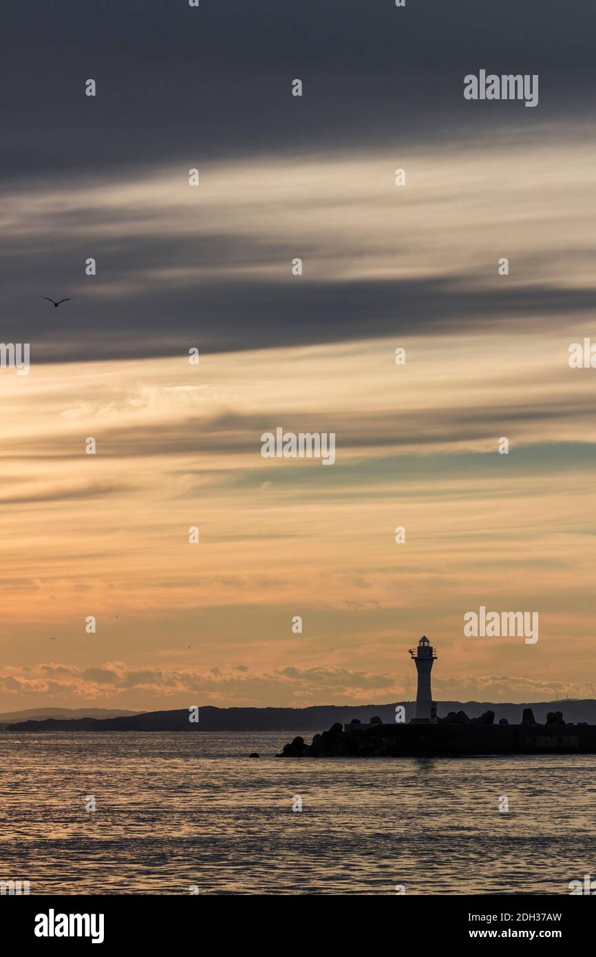 Kushiro Port Lighthouse dove la silhouette è proiettata nel cielo arancione al tramonto Foto Stock