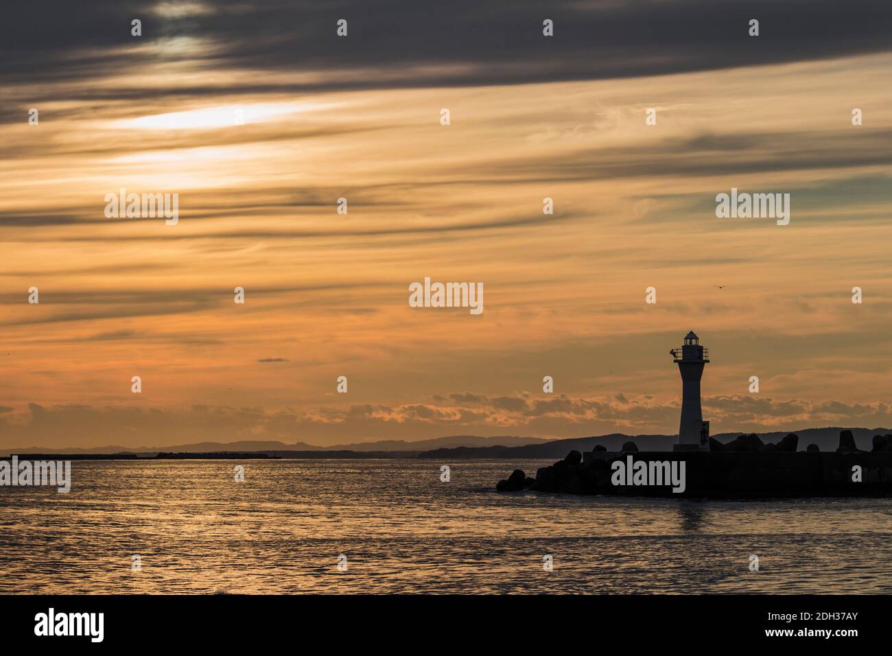 Kushiro Port Lighthouse dove la silhouette è proiettata nel cielo arancione al tramonto Foto Stock