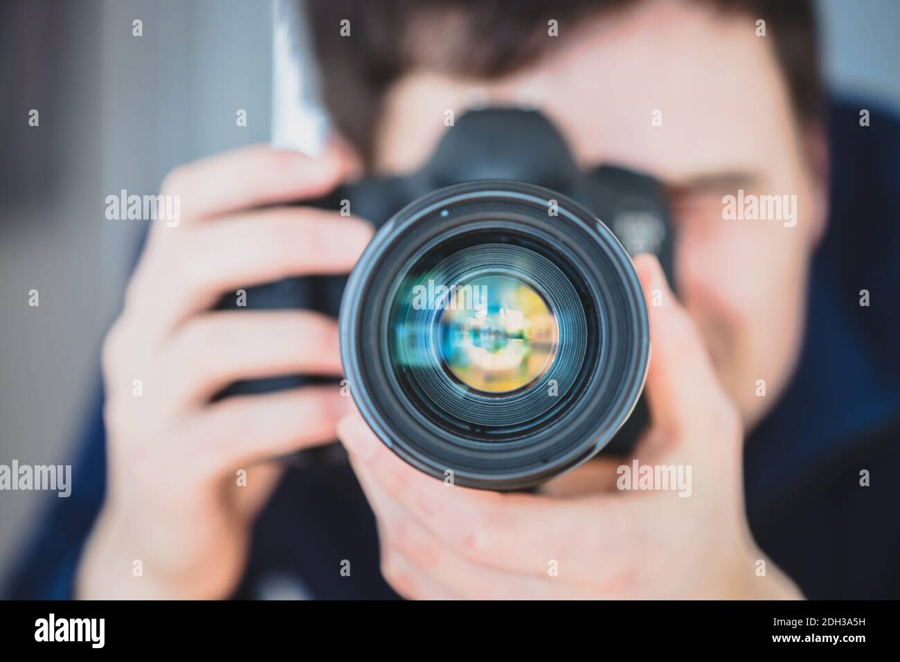 Fotografo al lavoro: L'uomo si trova dietro una fotocamera professionale su un treppiede, facendo foto Foto Stock