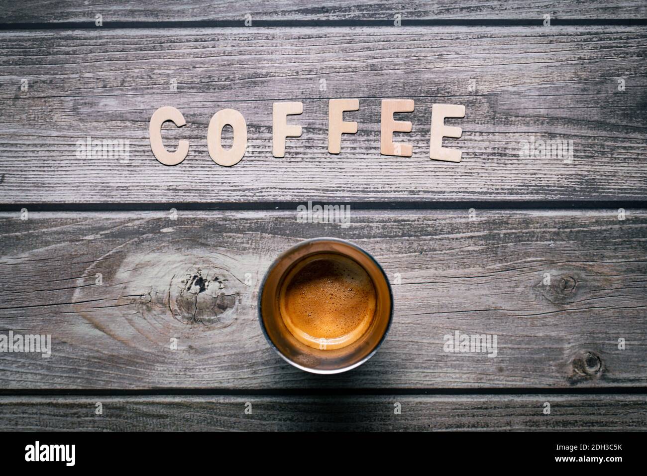 Caffè espresso marrone con lettere di legno che compongono il caffè su un tavolo di legno Foto Stock