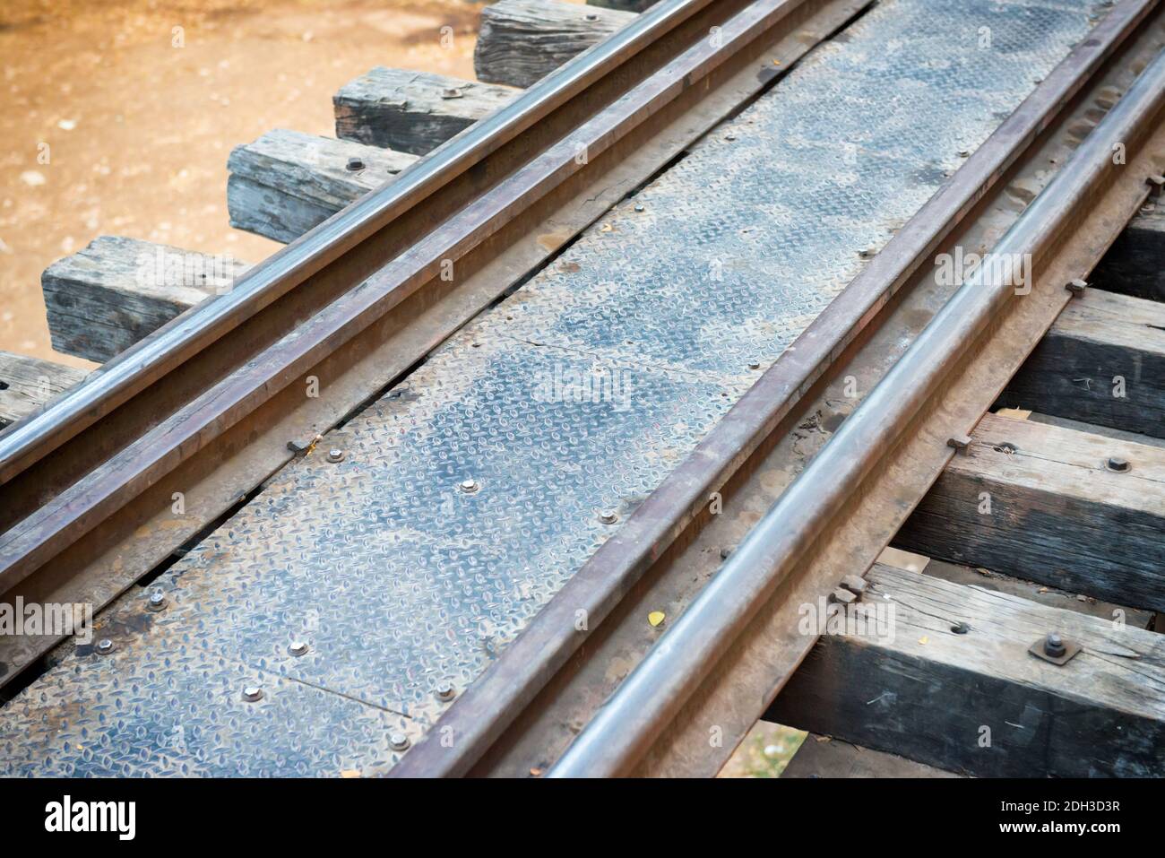 Vecchia pista con traversine di legno e ringhiere arrugginite Foto Stock