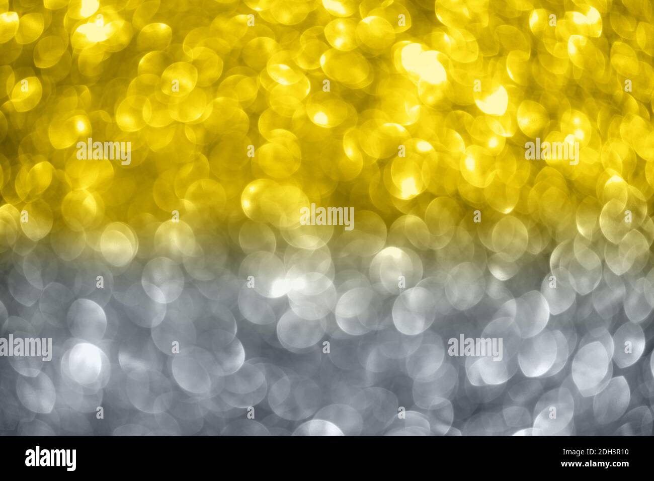 Sfondo bokeh giallo e grigio. Natale, Capodanno, festa, celebrazione concetto. Colore illuminante. Foto Stock