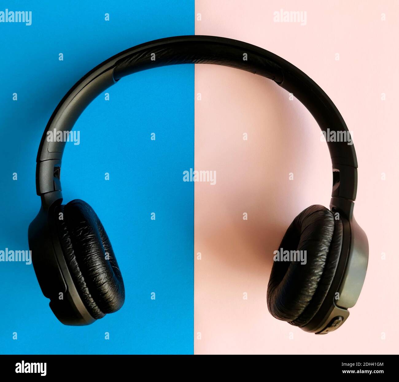 Cuffie audio su sfondo blu e rosa. Relax e musica Foto Stock