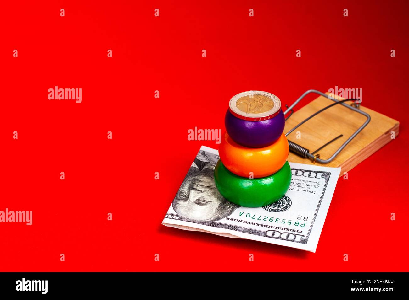 Un conto del dollaro e una piramide con una moneta in euro giacciono in un mousetrap. Concetto di piramide finanziaria, investimento. Foto Stock