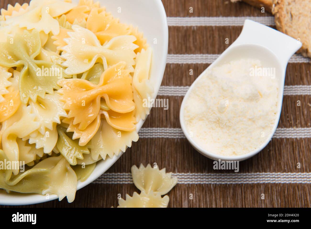 Piatto di farfalle italiana con formaggio grattugiato il tavolo Foto Stock