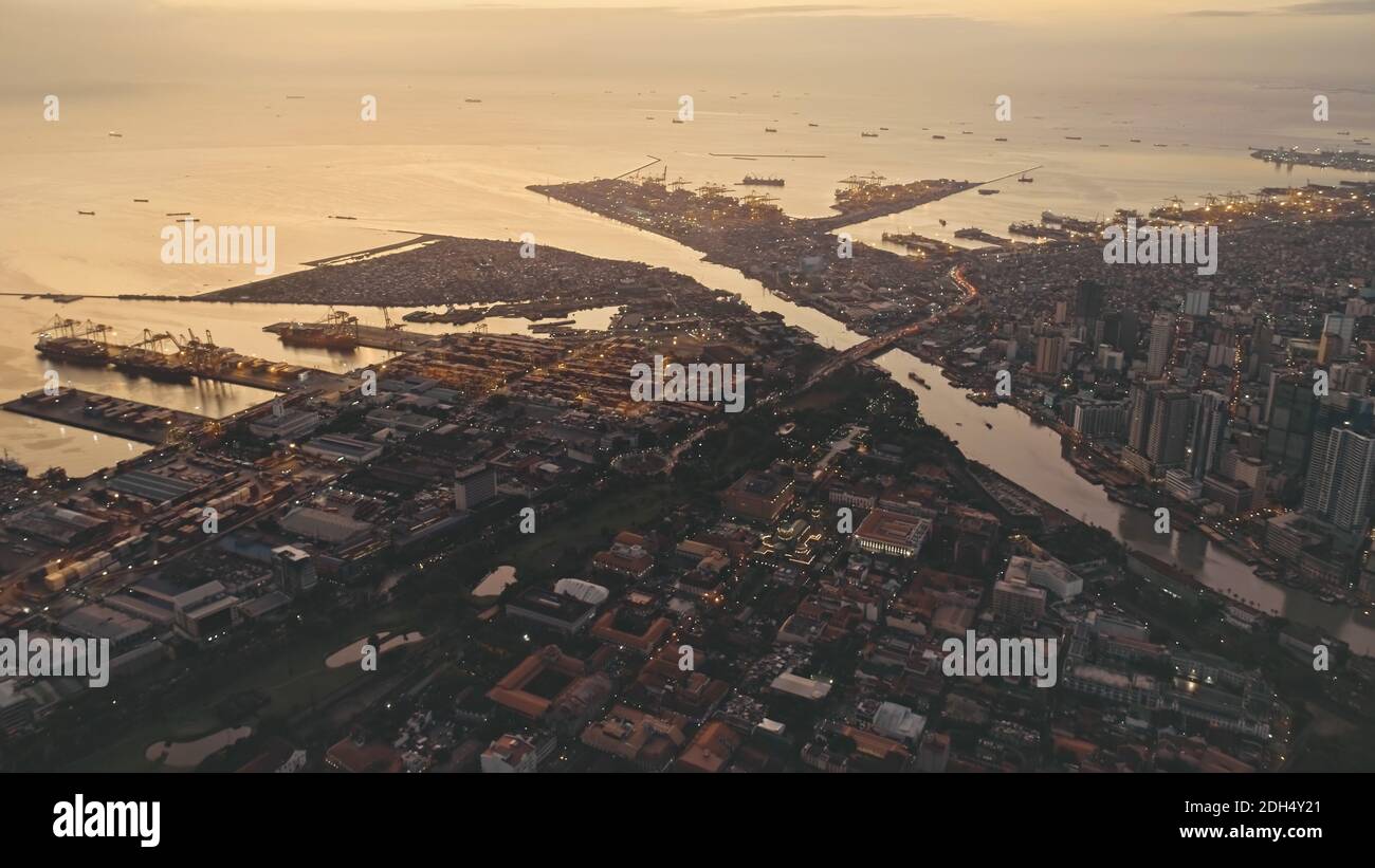 Tramonto a Ocean Bay con la città in riva al fiume. Paesaggio urbano illuminato con strade e strade. Scenario cinematografico alla luce solare estiva. Architettura moderna punto di riferimento della città di Manila, Filippine. Foto Stock