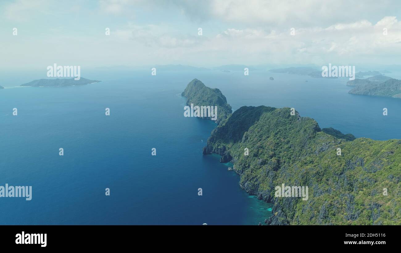 Isola montagnosa dell'Asia con paesaggio esotico di varietà della natura. Vista aerea dell'isola tropicale dell'altopiano sulla baia blu dell'oceano. Scenario estivo cinematografico dell'isolotto di Palawan, Filippine. Scatto morbido e leggero con drone Foto Stock