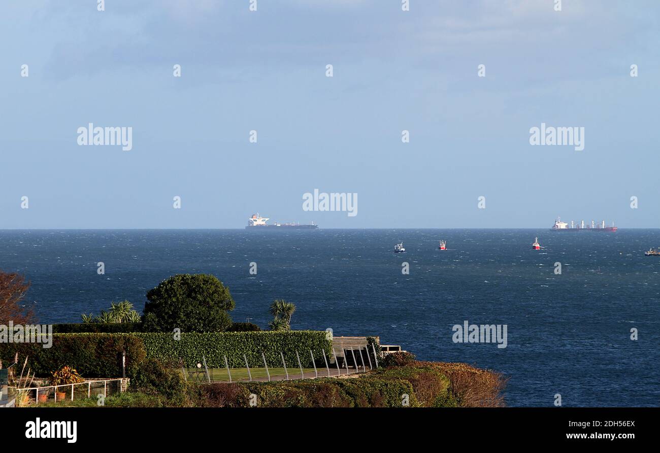 Torbay, Devon, Inghilterra: Due imbarcazioni costiere ormeggiate in lontananza e più piccole imbarcazioni che navigano attraverso Torbay nel mezzo. Foto Stock