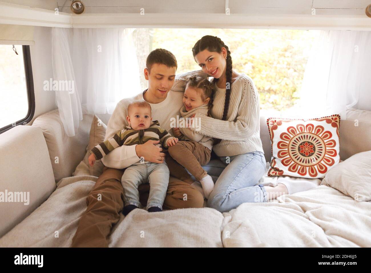 Ritratto della famiglia sorridente felice con i bambini nel casa su ruote Foto Stock