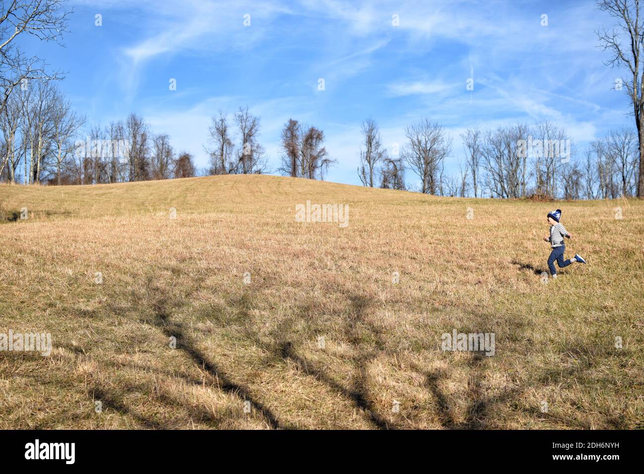 Ragazzo che corre in campo agricolo tempo invernale fuori Foto Stock
