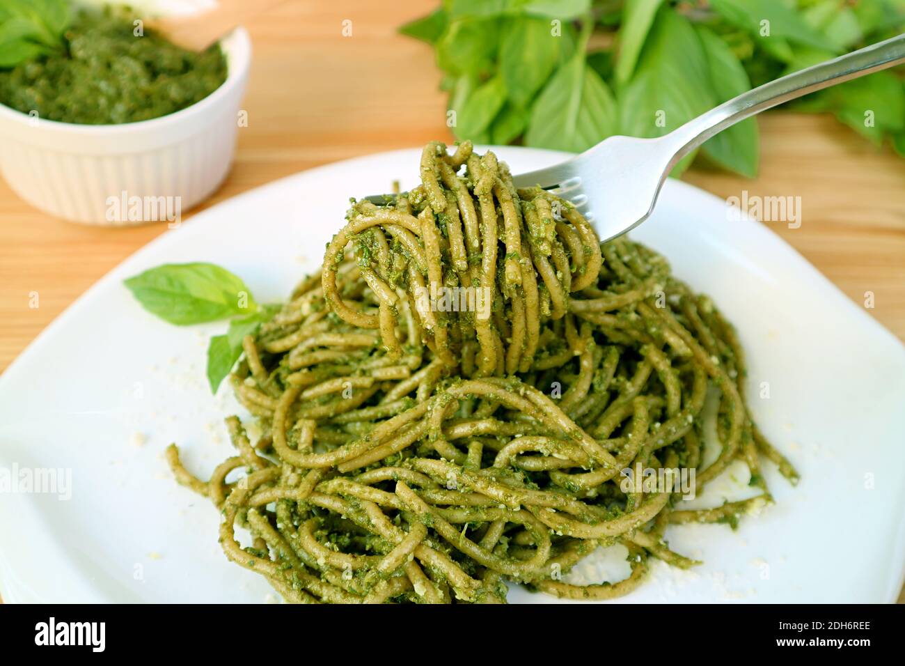 Forchetta che stuzzica gli spaghetti di grano intero con salsa al pesto Foto Stock