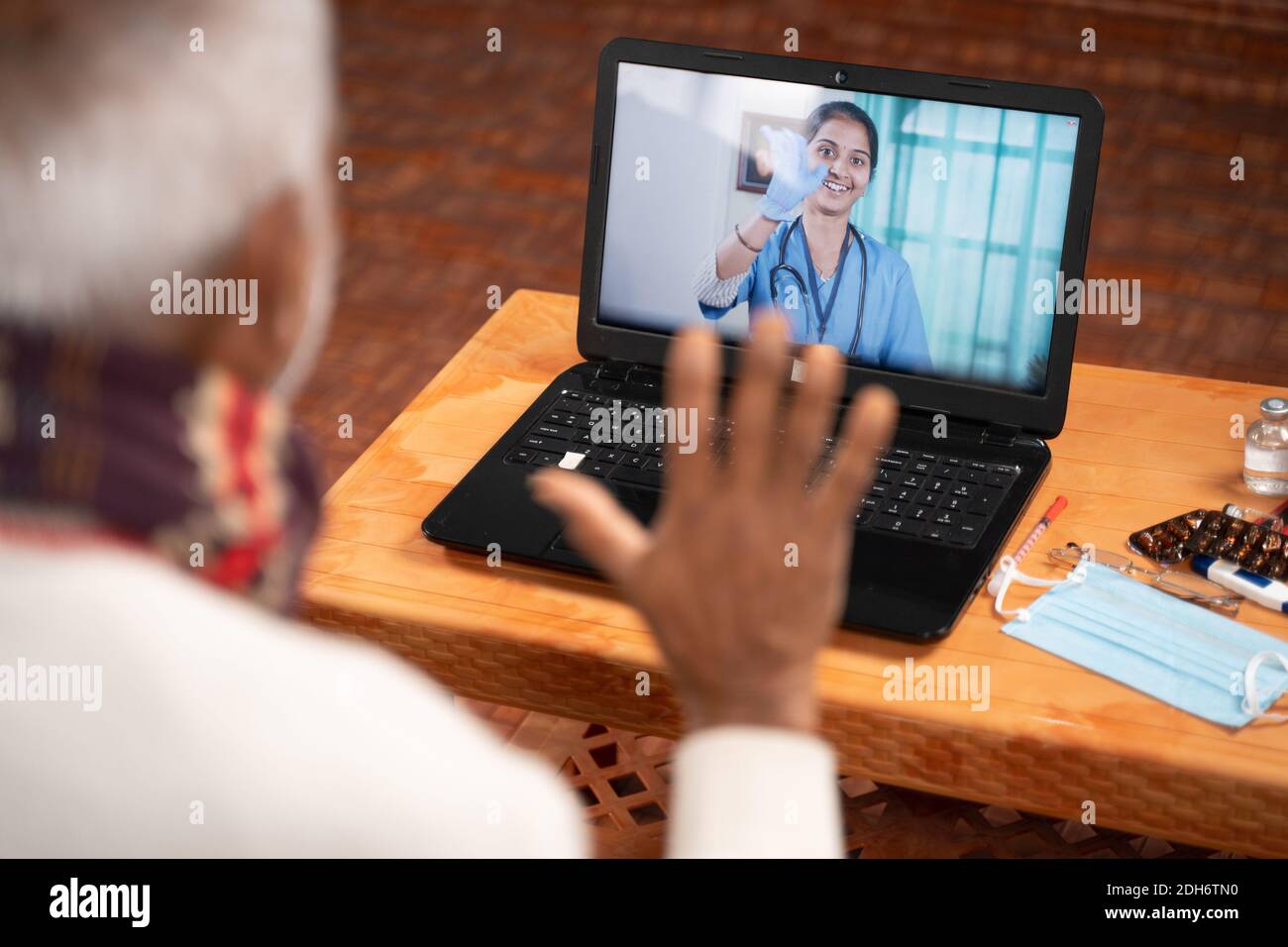 Spalla ripresa di vecchio uomo in video con il medico sullo schermo del portatile - concetto di chat online, telegHealth, o consulenza telefonica con infermiere o medico durante Foto Stock