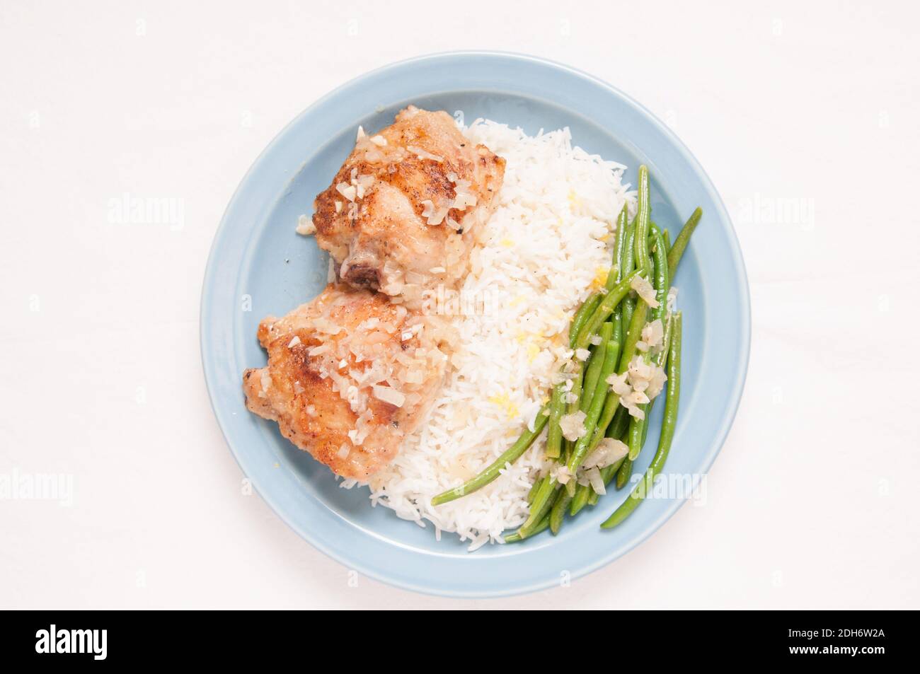 cosce di pollo fritte con verdure sopra riso in un salsa al limone Foto Stock