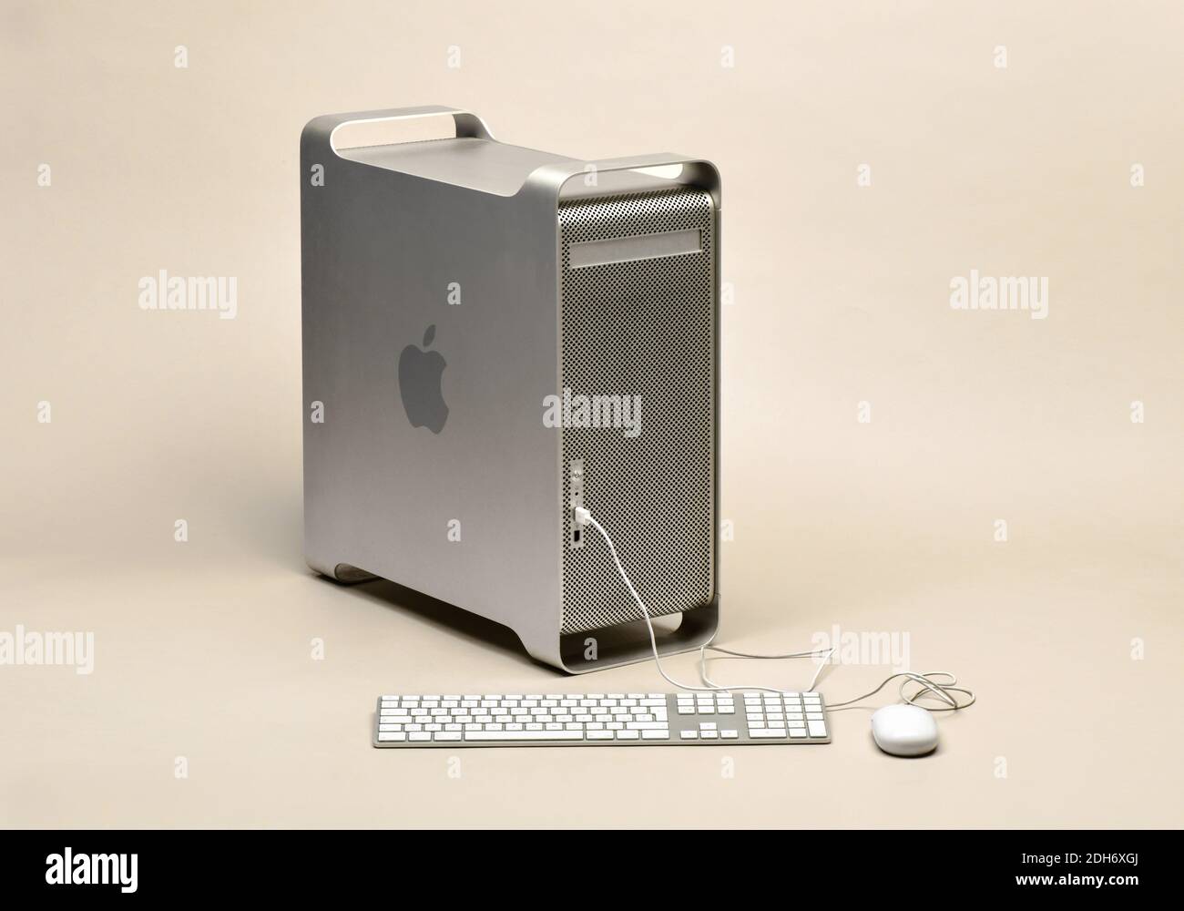 Computer Apple Power Mac G5 in custodia metallica con tastiera e mouse Apple originali collegati, isolato su sfondo beige Foto Stock