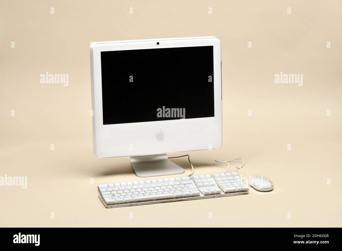 Apple iMac 17 pollici 2006 con tastiera e mouse isolati su sfondo beige. Primo computer Apple con CPU Intel Foto Stock