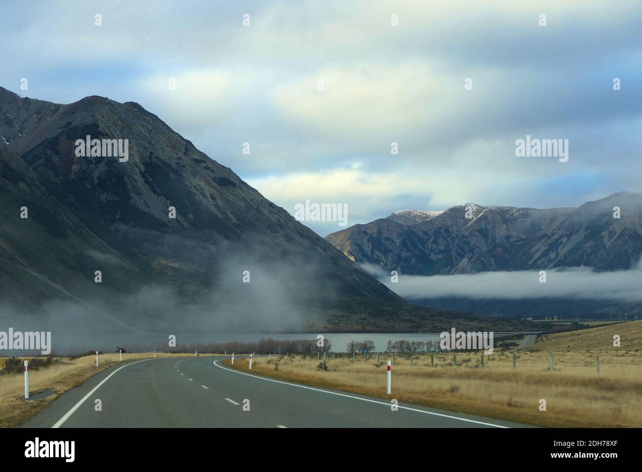 Strada di campagna solitaria attraverso il pittoresco paesaggio montano della Nuova Zelanda tra West Coast e Christchurch Foto Stock