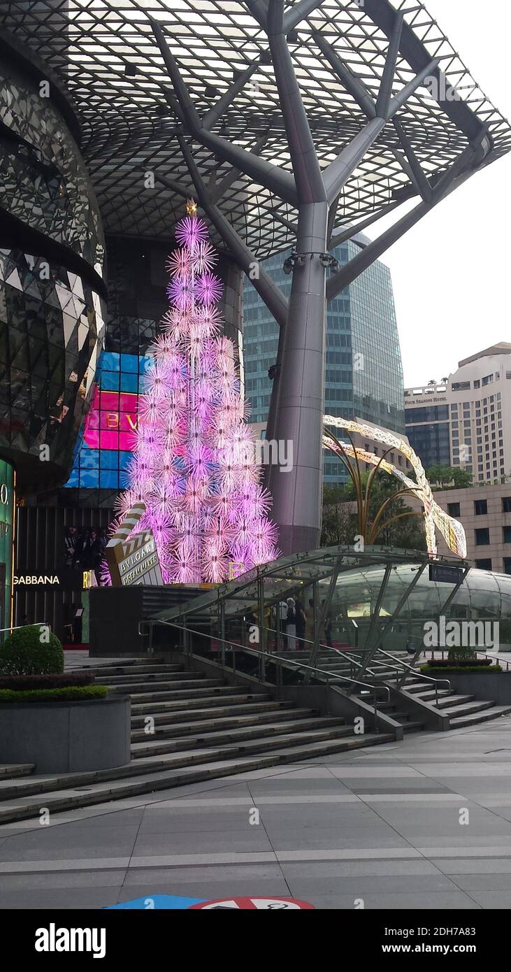 SINGAPORE, SINGAPORE - 11 Novembre 2019: Un albero di Natale elettrico in rosa, illuminato di giorno di fronte ad un Centro commerciale per i migliori marchi su Orchard Road Foto Stock