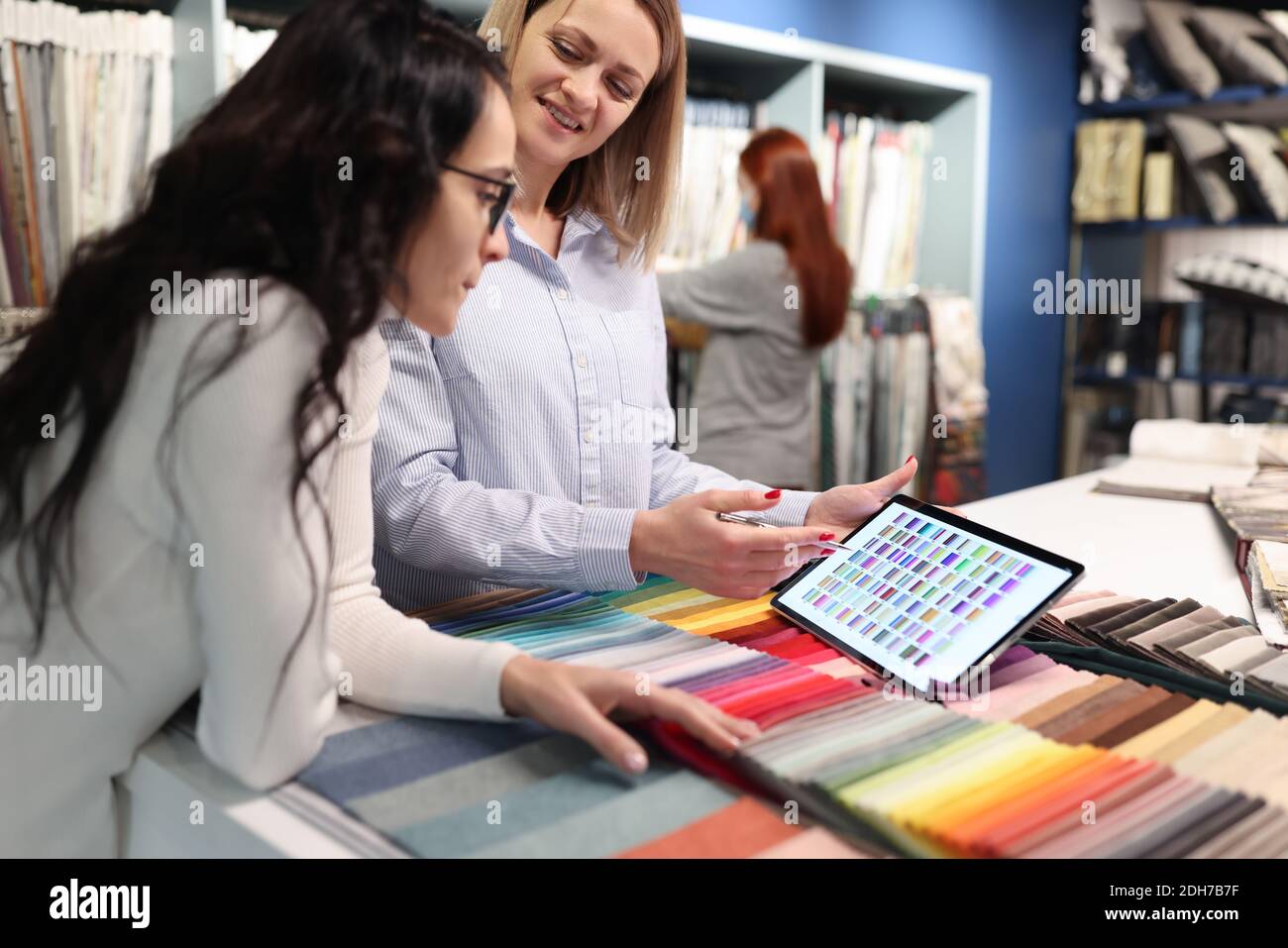 Designer e client esaminano la tavolozza dei colori sul tablet Foto Stock