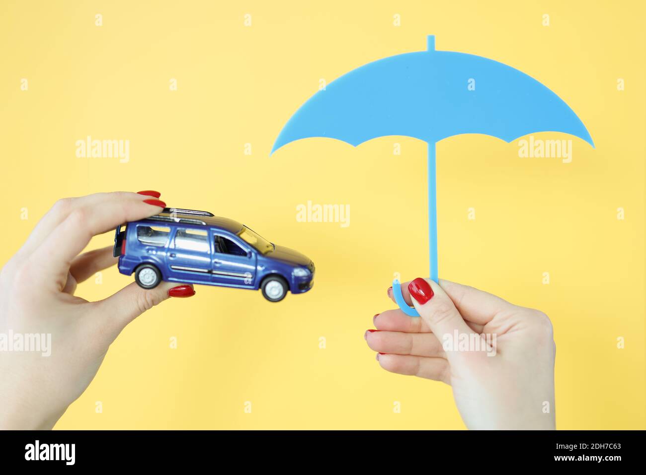 Stanno tenendo una macchina e un ombrello. Foto Stock