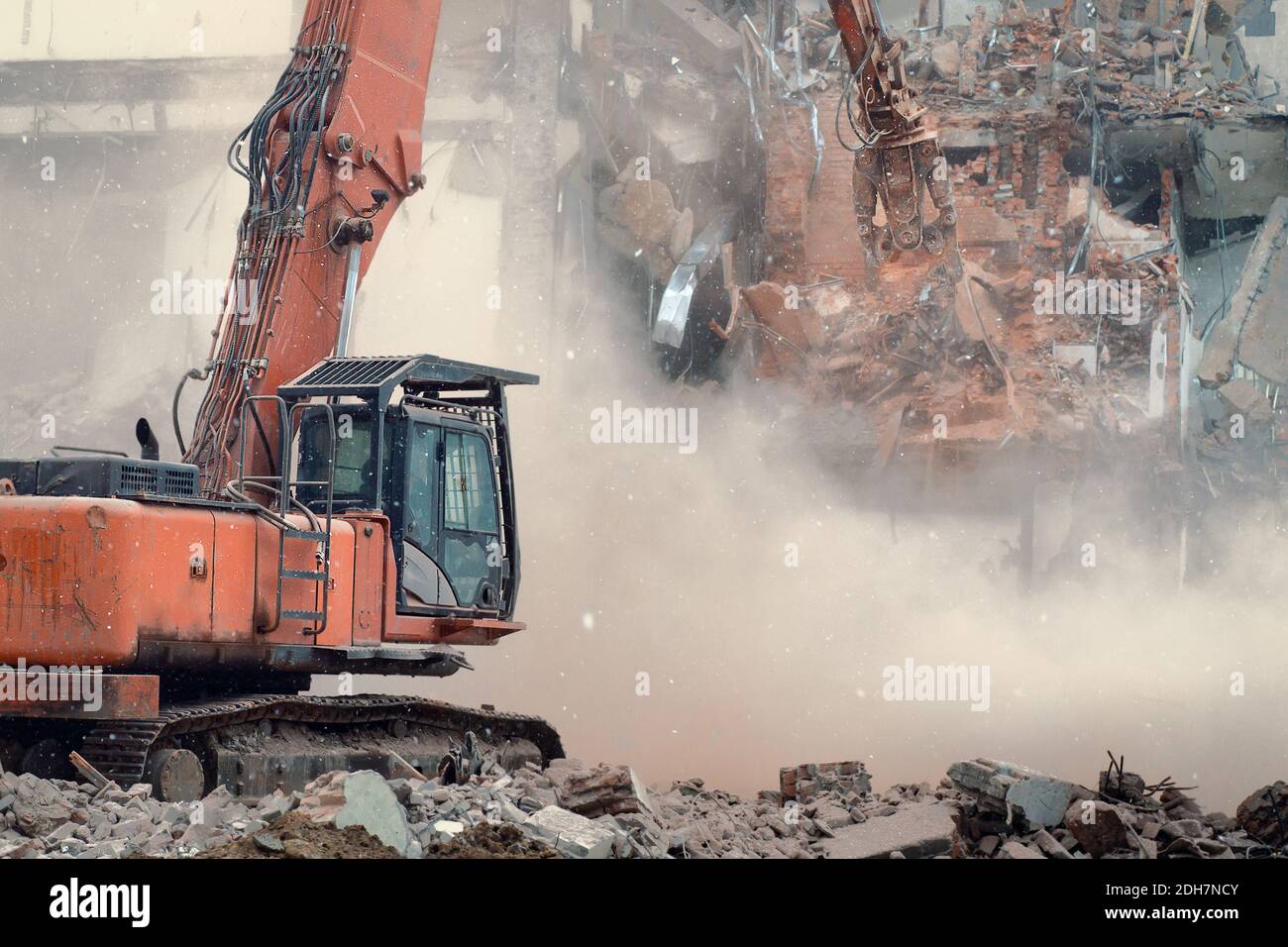 Lavori di demolizione di un vecchio edificio. L'escavatore demolisce un vecchio edificio con attrezzature speciali Foto Stock