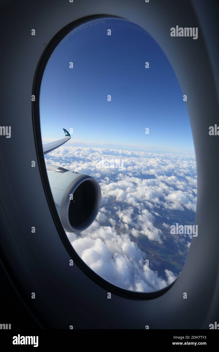 Vista delle nuvole attraverso la finestra dell'aeroplano e il motore a getto dell'aeroplano Foto Stock