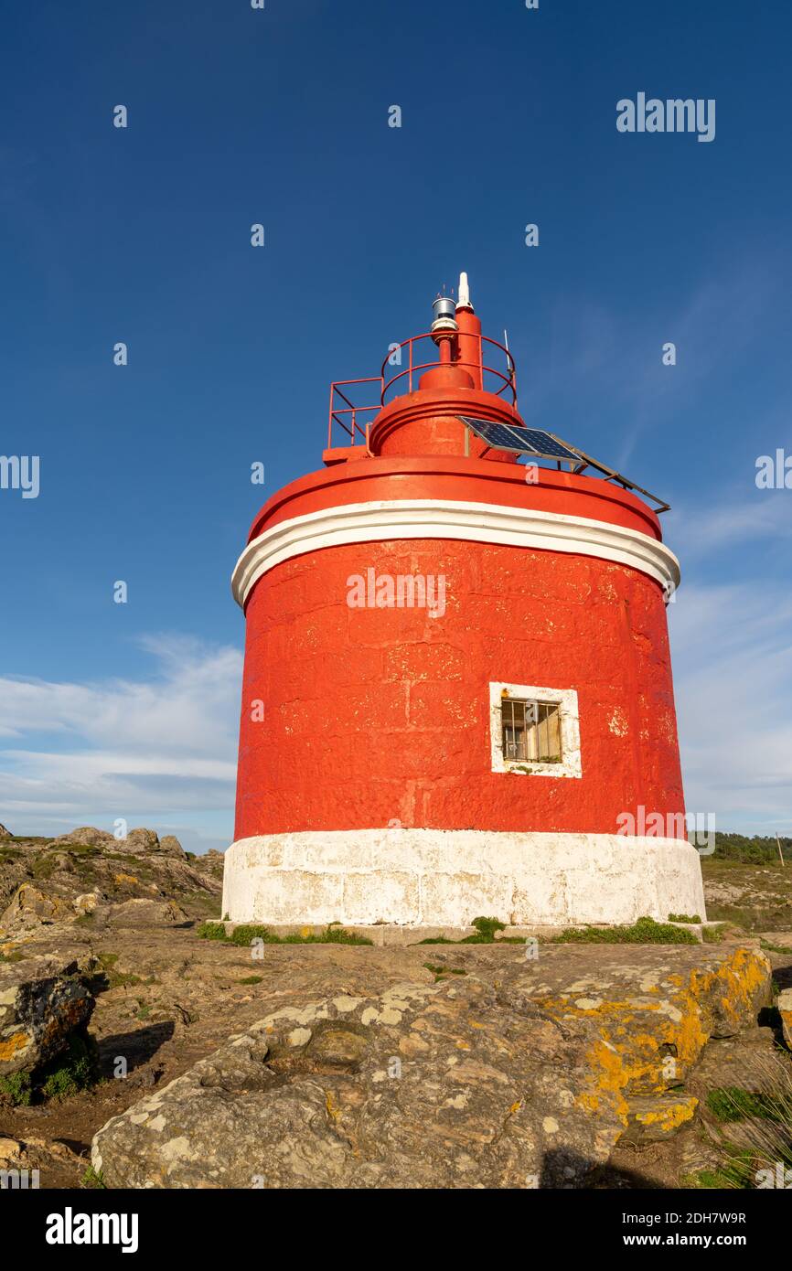 Vista sul faro rosso brillante di Punta Robaleira in Galizia Foto Stock