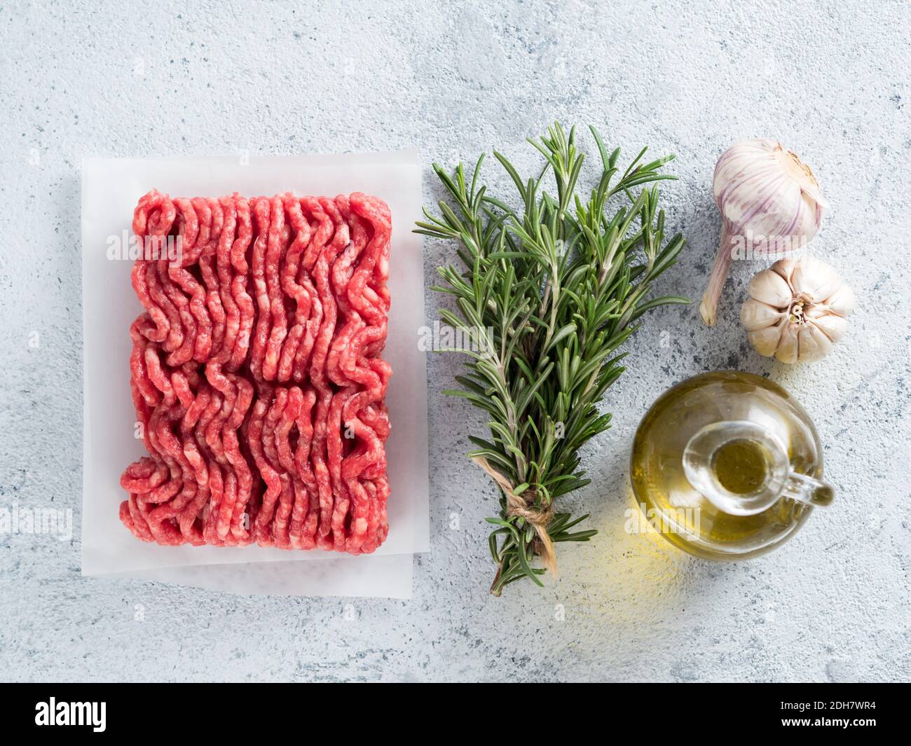 Carne macinata grezza, rosmarino, olio d'oliva. Vista dall'alto Foto Stock