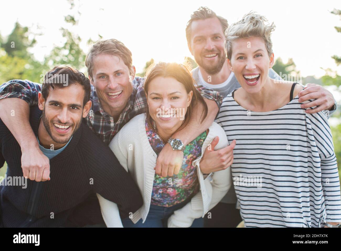 Ritratto di gruppo di amici felici che si divertano al pic-nic sul lungolago Foto Stock