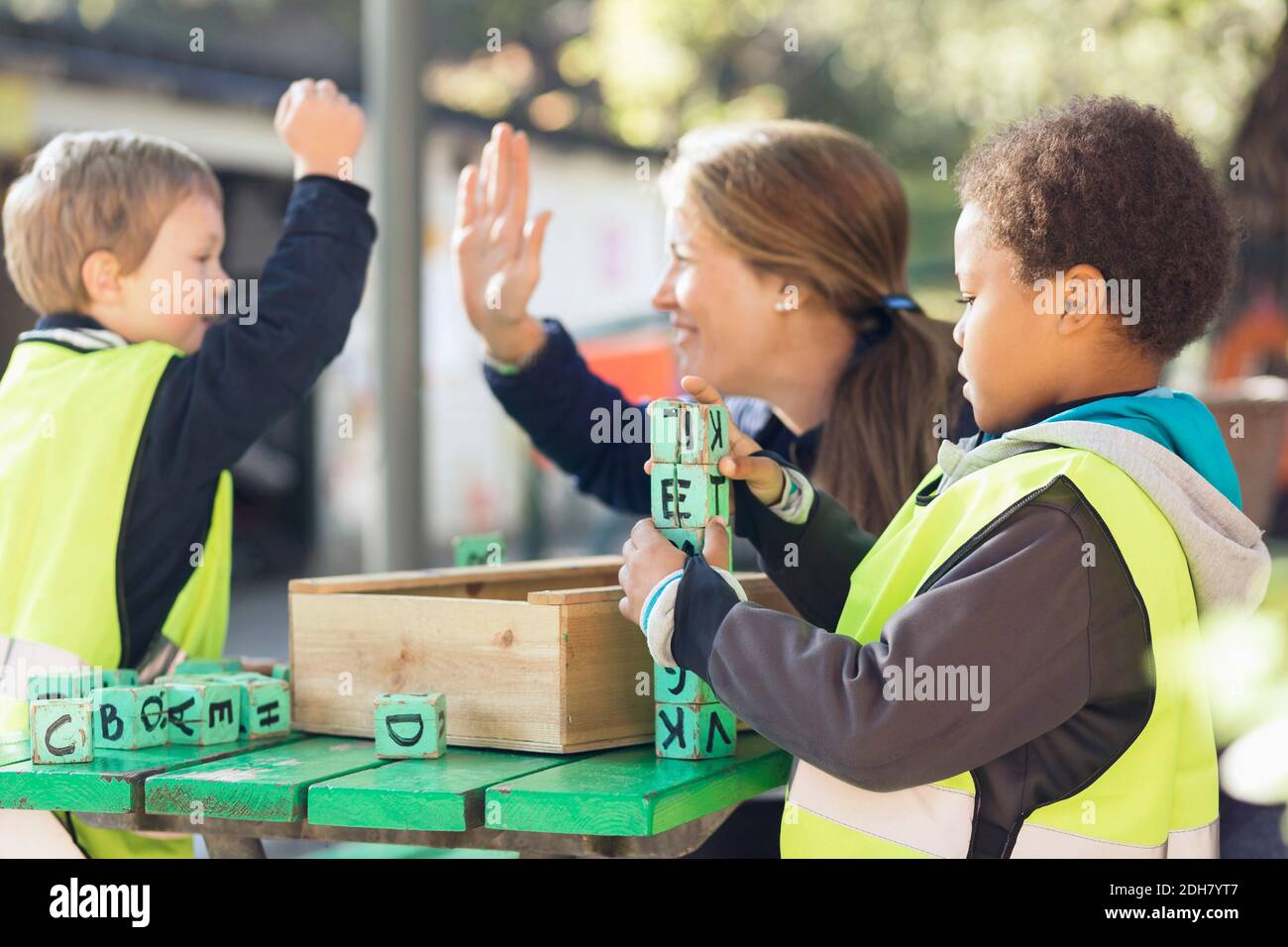 Insegnante che dà high-five allo studente mentre il ragazzo si blocca a. tabella Foto Stock