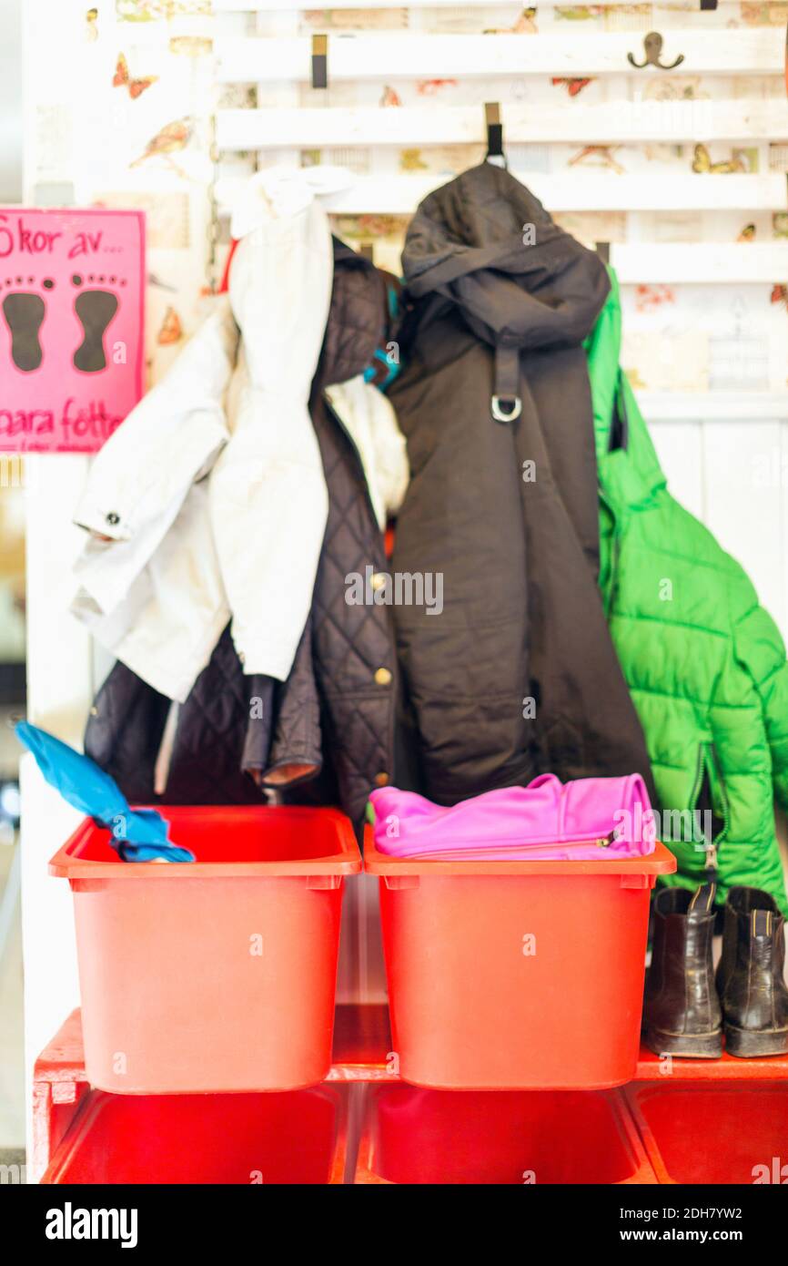 Contenitori e giacche all'esterno dell'asilo Foto Stock