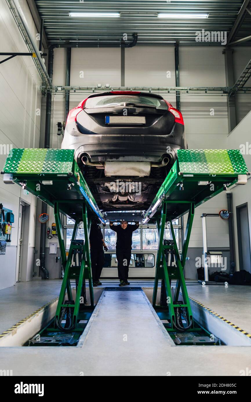 Auto sul sollevatore idraulico in officina di riparazione automatica Foto Stock