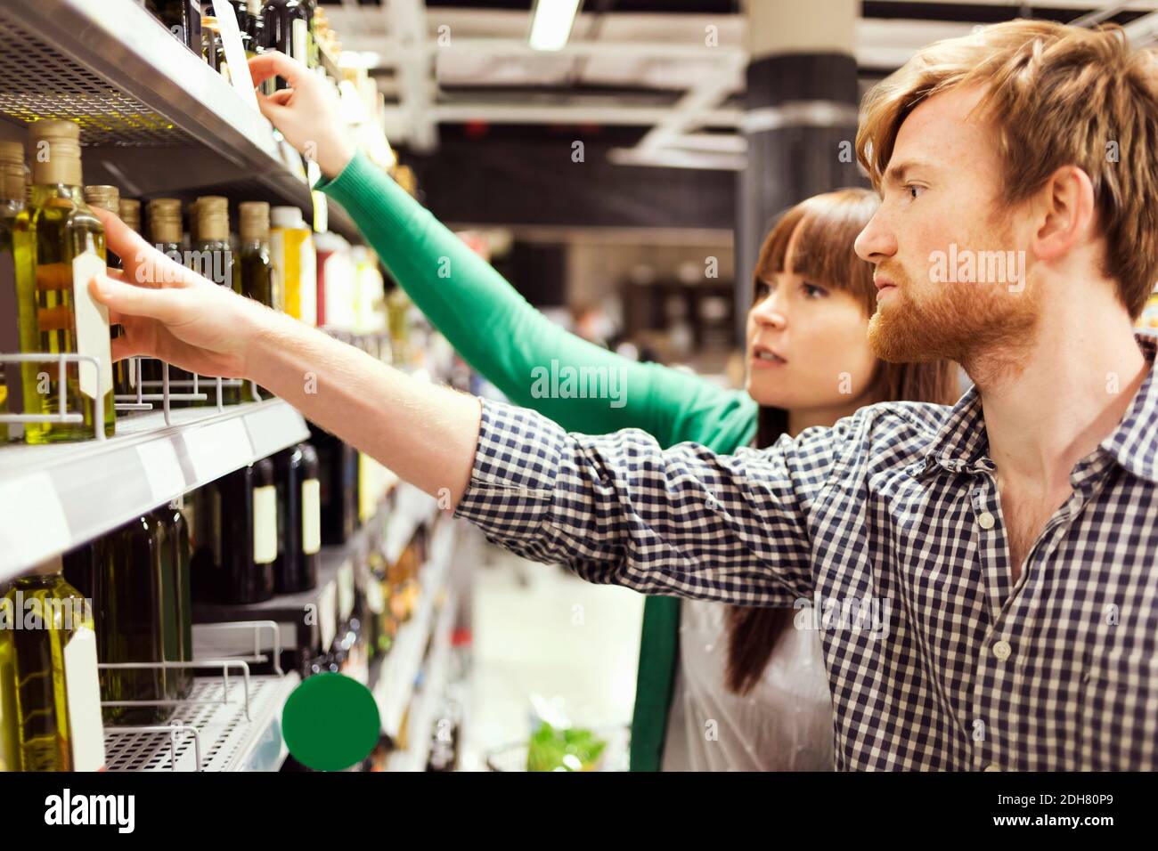 Giovane coppia che analizza i prodotti nel supermercato Foto Stock