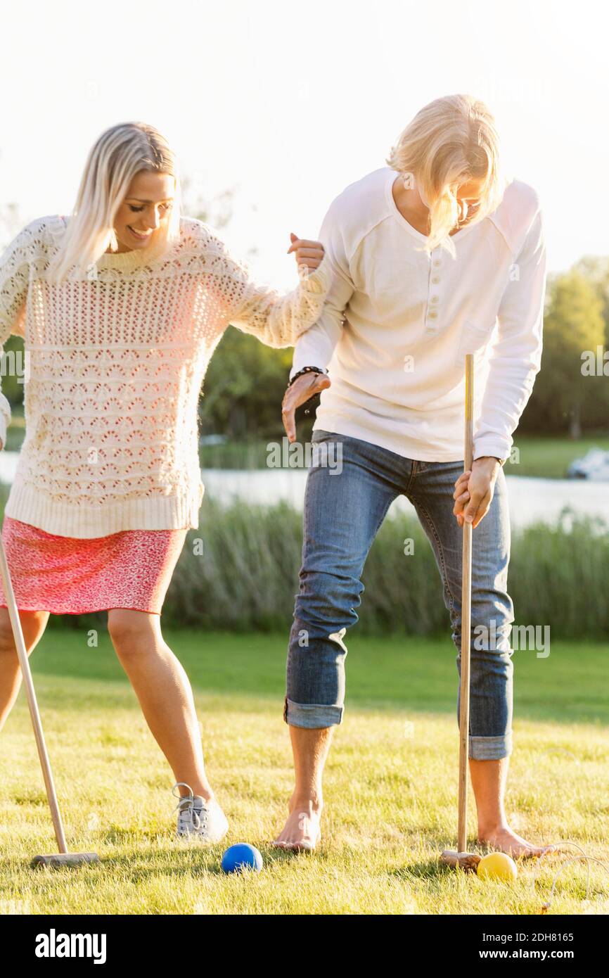 Amici felici che giocano il croquet sul campo Foto Stock