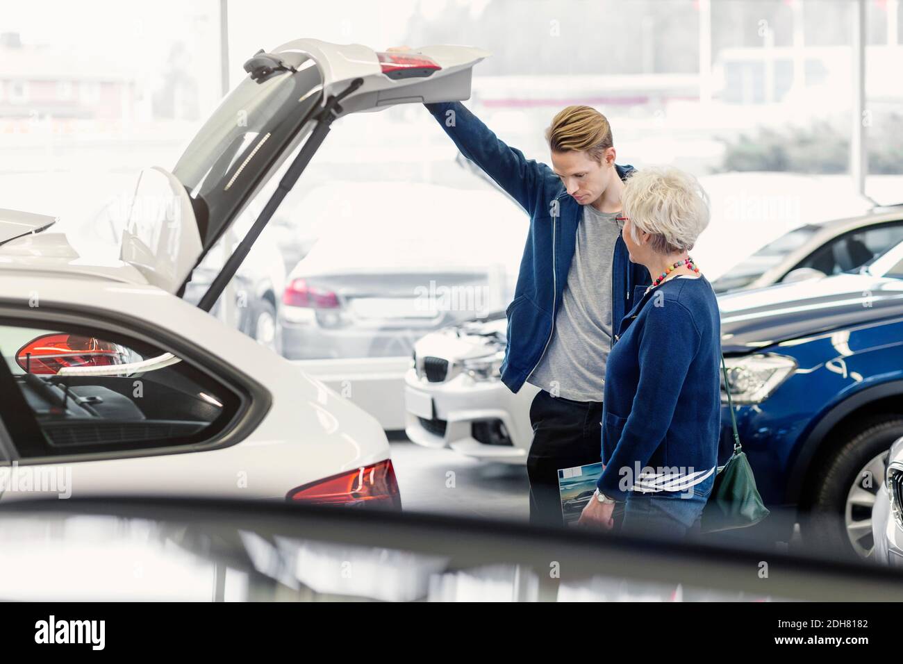 Madre e figlio esaminano l'auto nel negozio della concessionaria Foto Stock