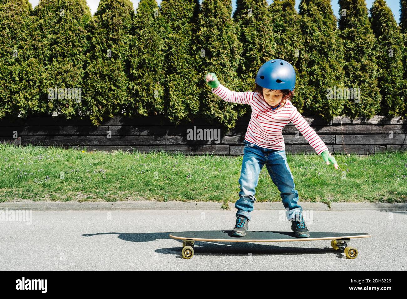 Tutta la lunghezza del bilanciamento del ragazzo sullo skateboard in cantiere Foto Stock