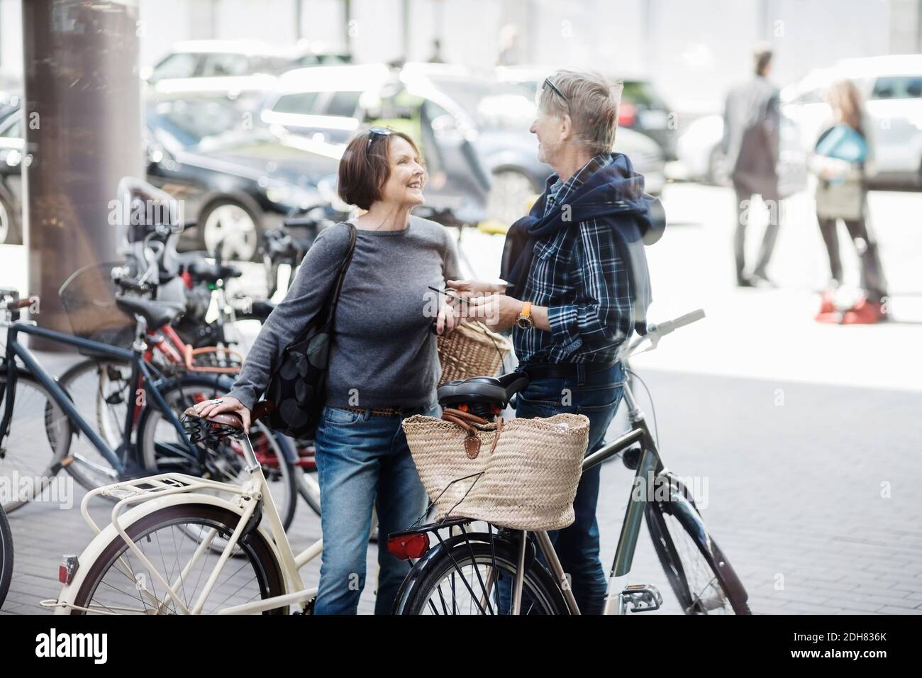 Felice coppia senior con biciclette in piedi sulla strada della città Foto Stock