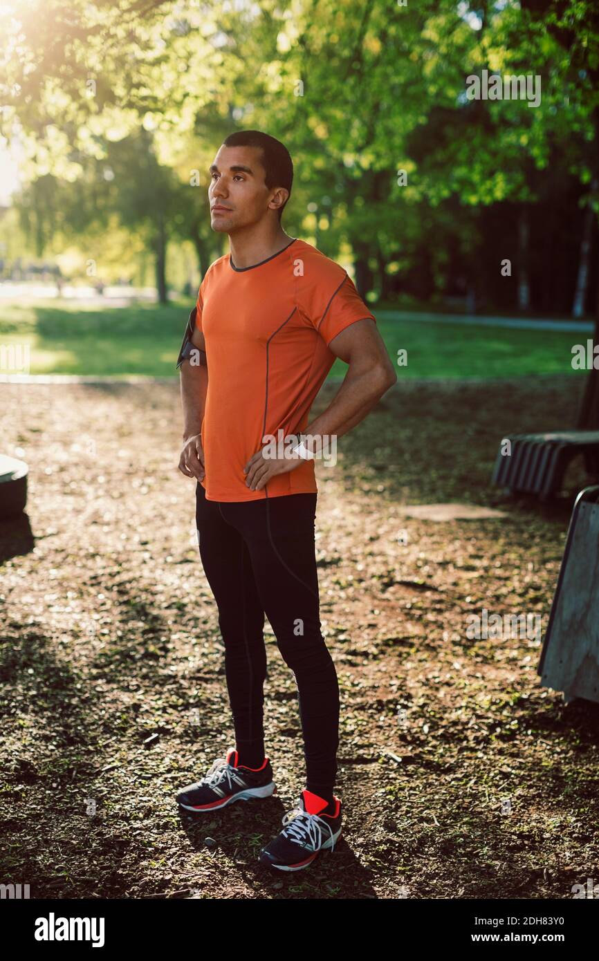 Uomo in piedi con le mani sull'anca al parco Foto Stock