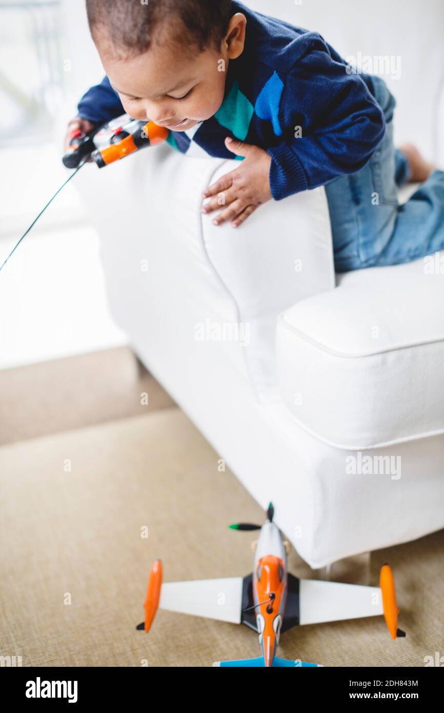 Ragazzo che gioca con un aereo telecomandato a casa Foto Stock