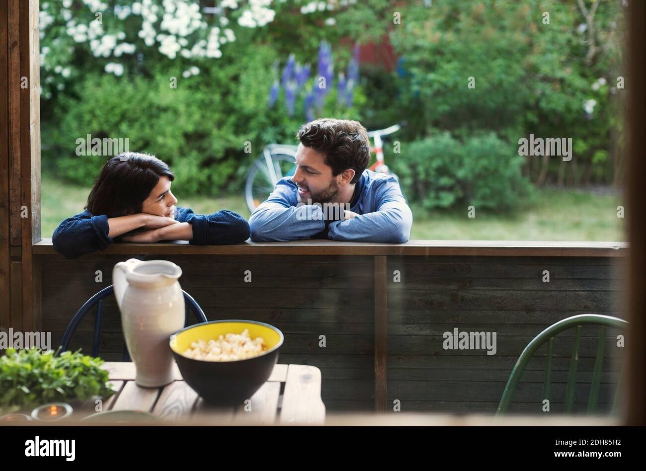 Coppia amorevole che guarda ciascuno mentre si appoggia sulla cabina di legno Foto Stock