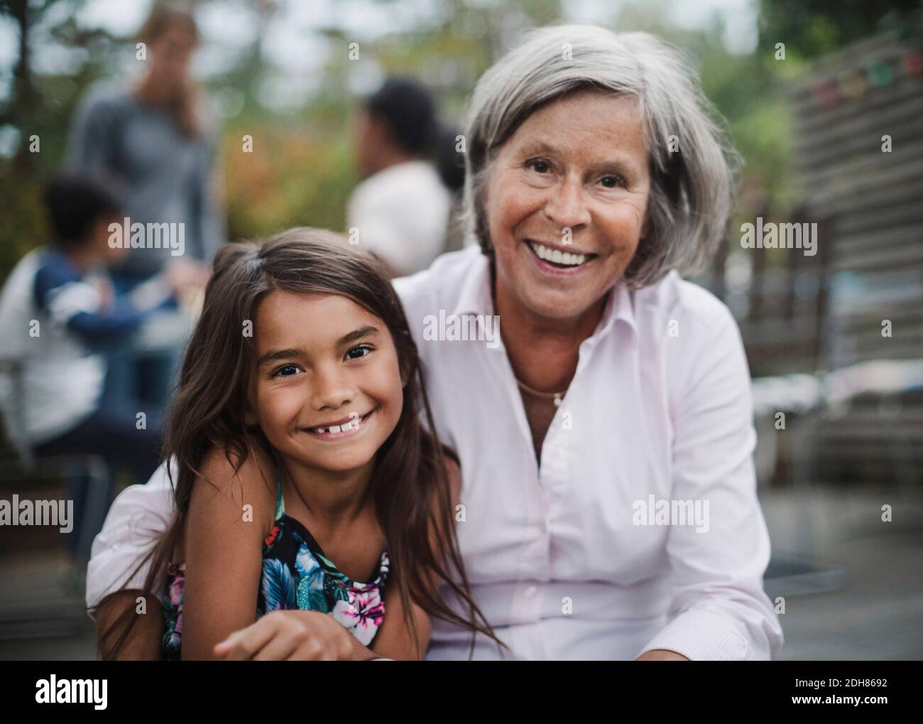 Ritratto di nonna felice seduta con nipote in cortile Foto Stock