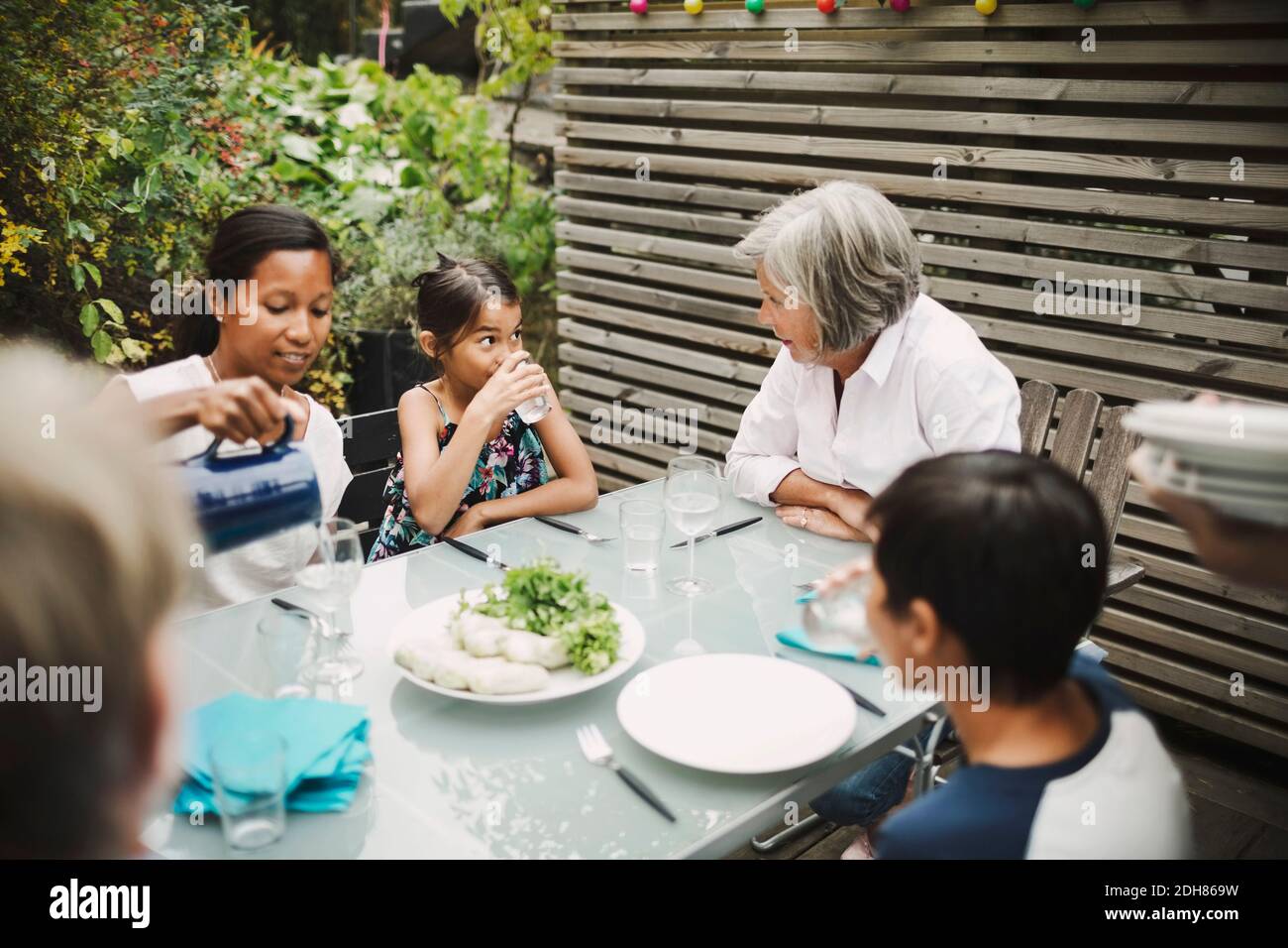 La famiglia ha mangiato al tavolo da pranzo all'aperto Foto Stock